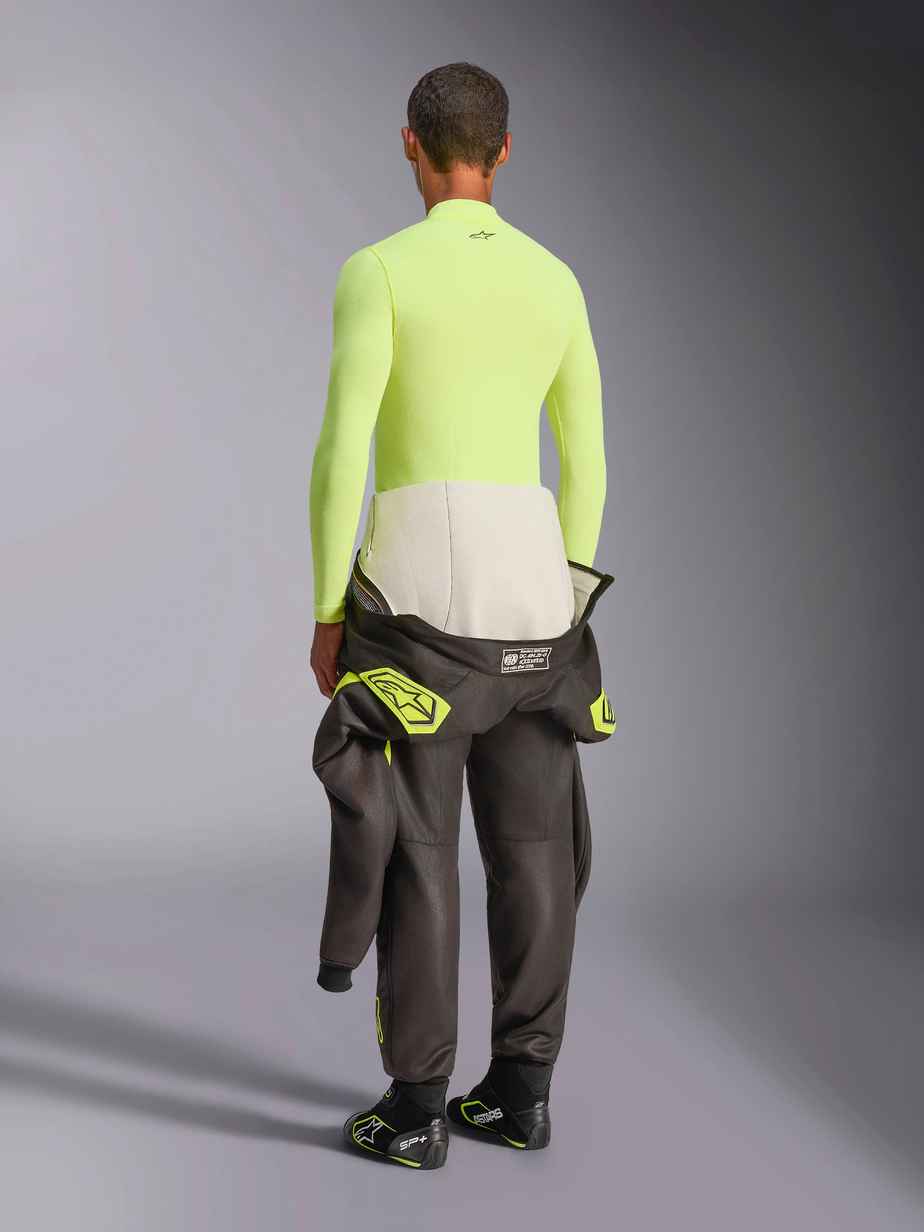 Alpinestars ZX Evo V3 Long Sleeve Top, Yellow Fluo, rear view of model wearing fire-resistant base layer with dark racing suit pants and boots, professional motorsport technical underwear