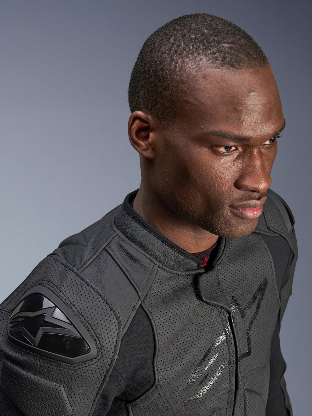 Nærbillede af en model iført Alpinestars Dusk Airflow læderjakke, sort i sort, med omfattende perforeret læder for åndbarhed, eksterne DFS-skulder-sliders og et strømlinet, moderne design til sportskørsel.