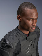 Nærbillede af en model iført Alpinestars Dusk Airflow læderjakke, sort i sort, med omfattende perforeret læder for åndbarhed, eksterne DFS-skulder-sliders og et strømlinet, moderne design til sportskørsel.