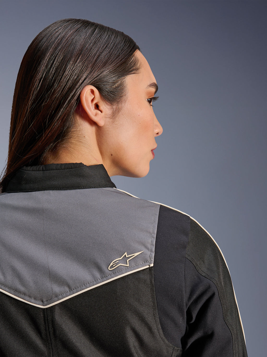 Alpinestars Stella T-Dyno WR-jakke, motorcykeljakke til kvinder, sort, mørkegrå og ecru, nærbillede bagfra af skulder og bærestykke med gråt panel og ecru stjernelogo, vintage-inspireret køreudstyr