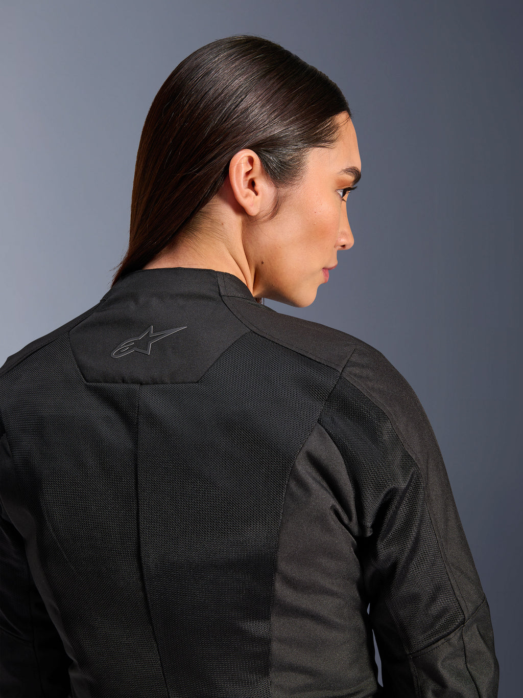 Alpinestars Stella C-1 Air jakke til damer, tekstil motorcykeljakke, sort, nærbillede bagfra der viser tech mesh-ventilationspaneler og et reflekterende stjernelogo på øverste del af ryggen, moderne urbant køreudstyr