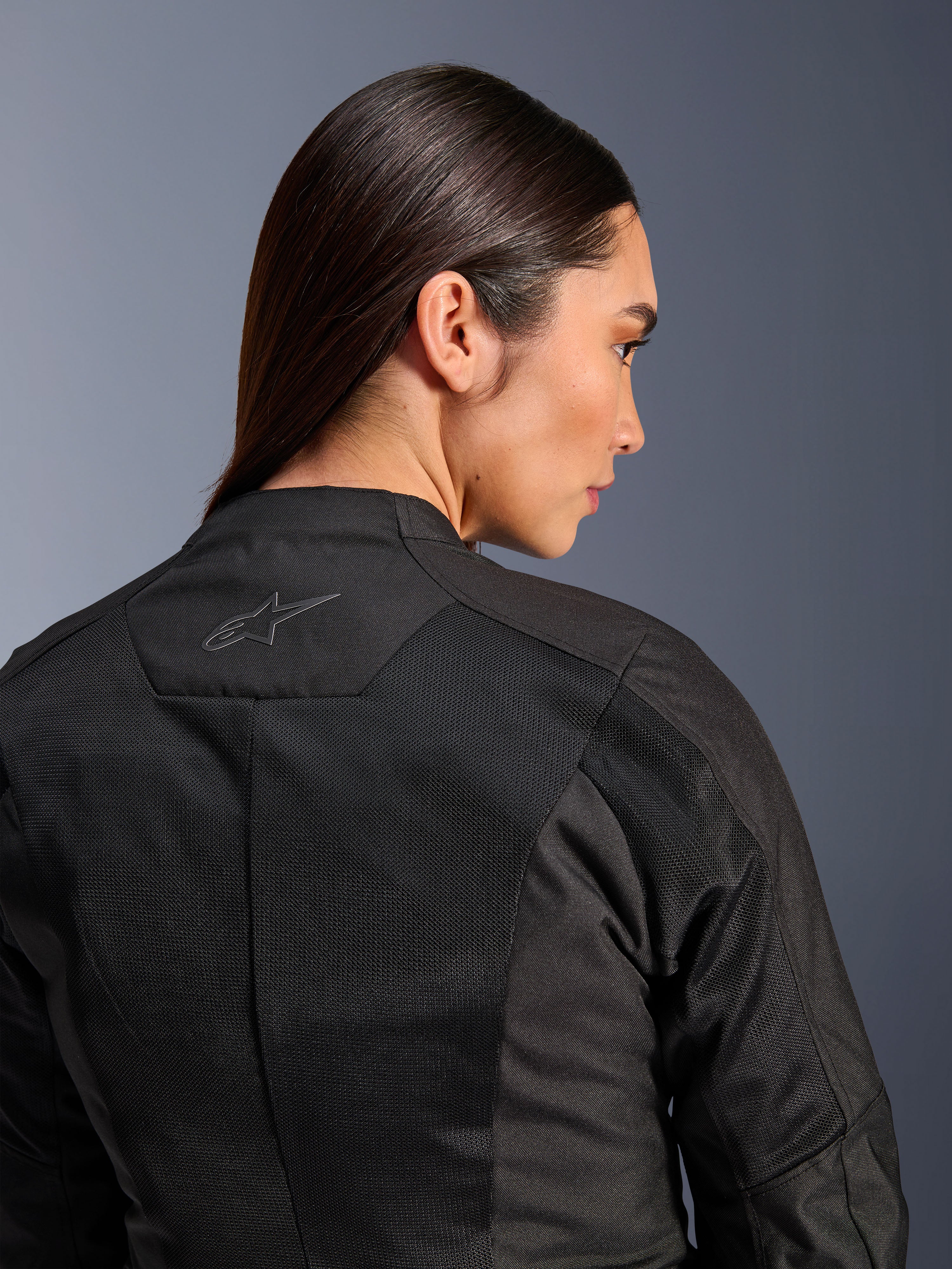 Alpinestars Stella C-1 Air jakke til damer, tekstil motorcykeljakke, sort, nærbillede bagfra der viser tech mesh-ventilationspaneler og et reflekterende stjernelogo på øverste del af ryggen, moderne urbant køreudstyr