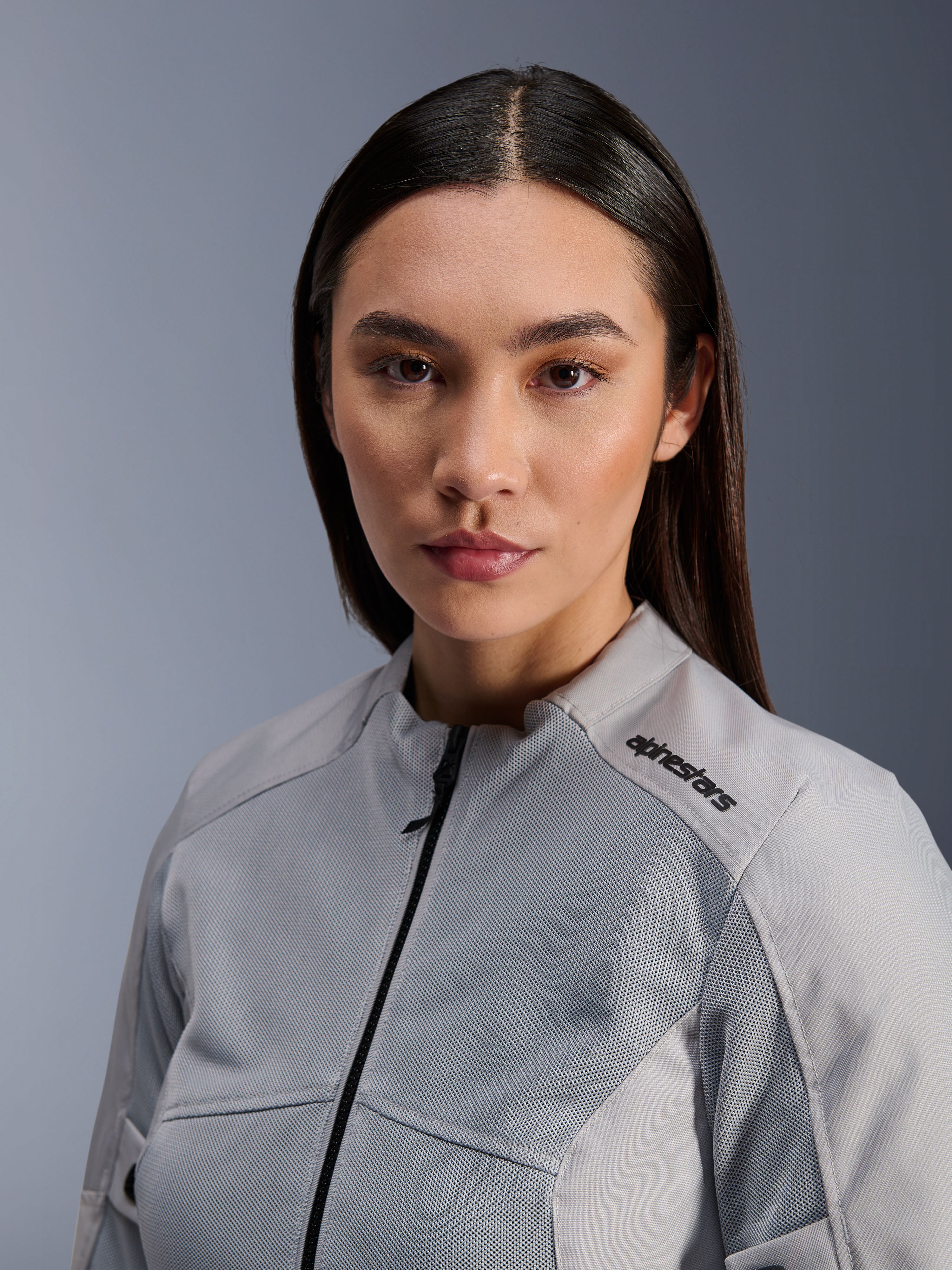 Alpinestars Stella C-1 Air Jakke, sølvfarvet motorcykeljakke til damer, tæt portræt der viser tech mesh-ventilationspaneler og sort logo på skulderen, urbant moderne køreudstyr