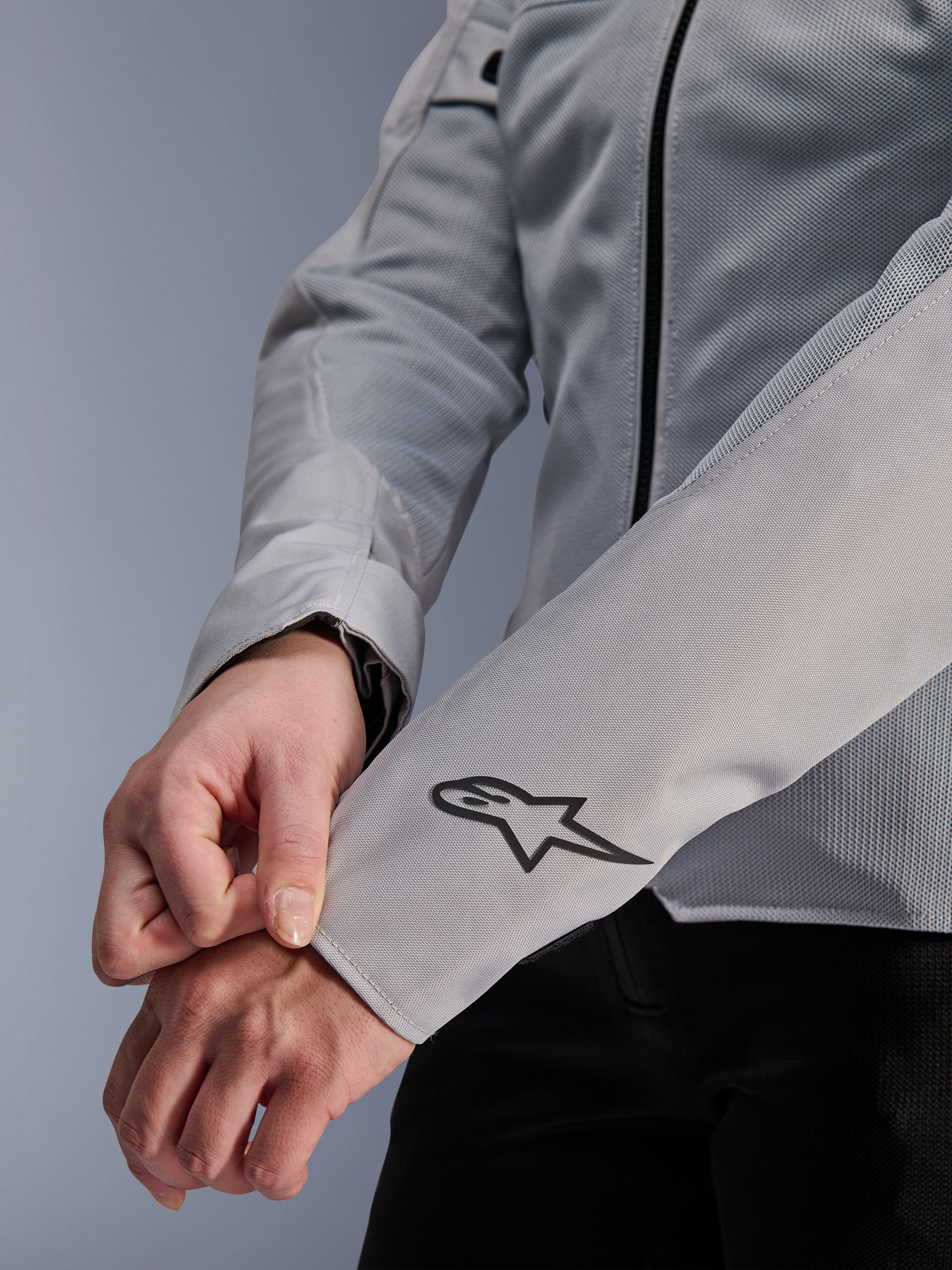Nærbillede af Alpinestars Stella C-1 Air-jakke i sølv, med teknisk mesh-konstruktion og et sort Alpinestars-logo på venstre ærme, urban motorcykeljakke til kvinder med reflekterende branding