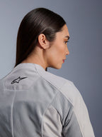 Kvinde iført Alpinestars Stella C-1 Air-jakke i sølv, nærbillede set fra siden og bagfra, sort Alpinestars-logo, tech mesh-ventilationspaneler, rent og moderne urbant motorcykeldesign