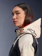 Alpinestars Molly Air-jakke, Black Almond, moderne urban motorcykeljakke, sideprofil af model iført hætten med Alpinestars-logo og orange snoretræksdetaljer, ripstop-tekstur