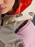 Nærbillede af Alpinestars Molly Air-jakken i Sand Pink Almond, der fremhæver skulderrummet med lynlås til Nucleon Flex-beskyttere, den klare orange mesh-foring i hætten og den slidstærke ripstop-tekstilkonstruktion.
