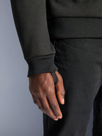 Alpinestars Chrome V2 Sport Hoodie, sort tech fleece, nærbillede af ribstrikket ærmemanchet med integreret tommelfingerstrop for stabilitet under kørsel, detalje på urbant motorcykeltøj