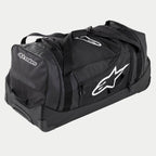 Alpinestars Komodo rejsetaske, stor taske til motocross-udstyr i sort og antracit med hvide logoer, udstyret med hjul og et teleskopisk håndtag, holdbar konstruktion til transport af racerudstyr