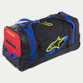 Alpinestars Komodo rejsetaske, udstyrstaske med hjul, sort, blå, rød og fluorescerende gul, med blå webbing-håndtag, et rødt sidepanel og fluorescerende gule logoer, holdbar konstruktion med hjul til transport af motocross- og racerudstyr