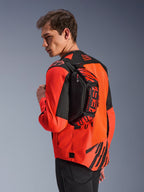 Alpinestars MM93 Waist Bag, sort med rød fluo og klar rød, båret af en model hen over ryggen over en rød og sort motorcykeljakke, med markant MM93-branding og Marc Marquez-grafik