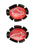 Alpinestars GP Tech knæslidere, røde og hvide, knæbeskyttere til motorcykelracing, stort hvidt stjerne-logo på blank rød plast, 'ONE GOAL. ONE VISION.' tekst på sort kronbladsformet velcrobagside, sæt med højre og venstre til banebrug