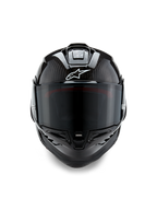 Alpinestars Supertech R10 Solid hjelm, set forfra, sort kulfiber i mat og blank finish, synlig kulfibervævning, hvidt Alpinestars-logo, mørkt røgfarvet visir, aerodynamisk racing-motorcykelhjelm