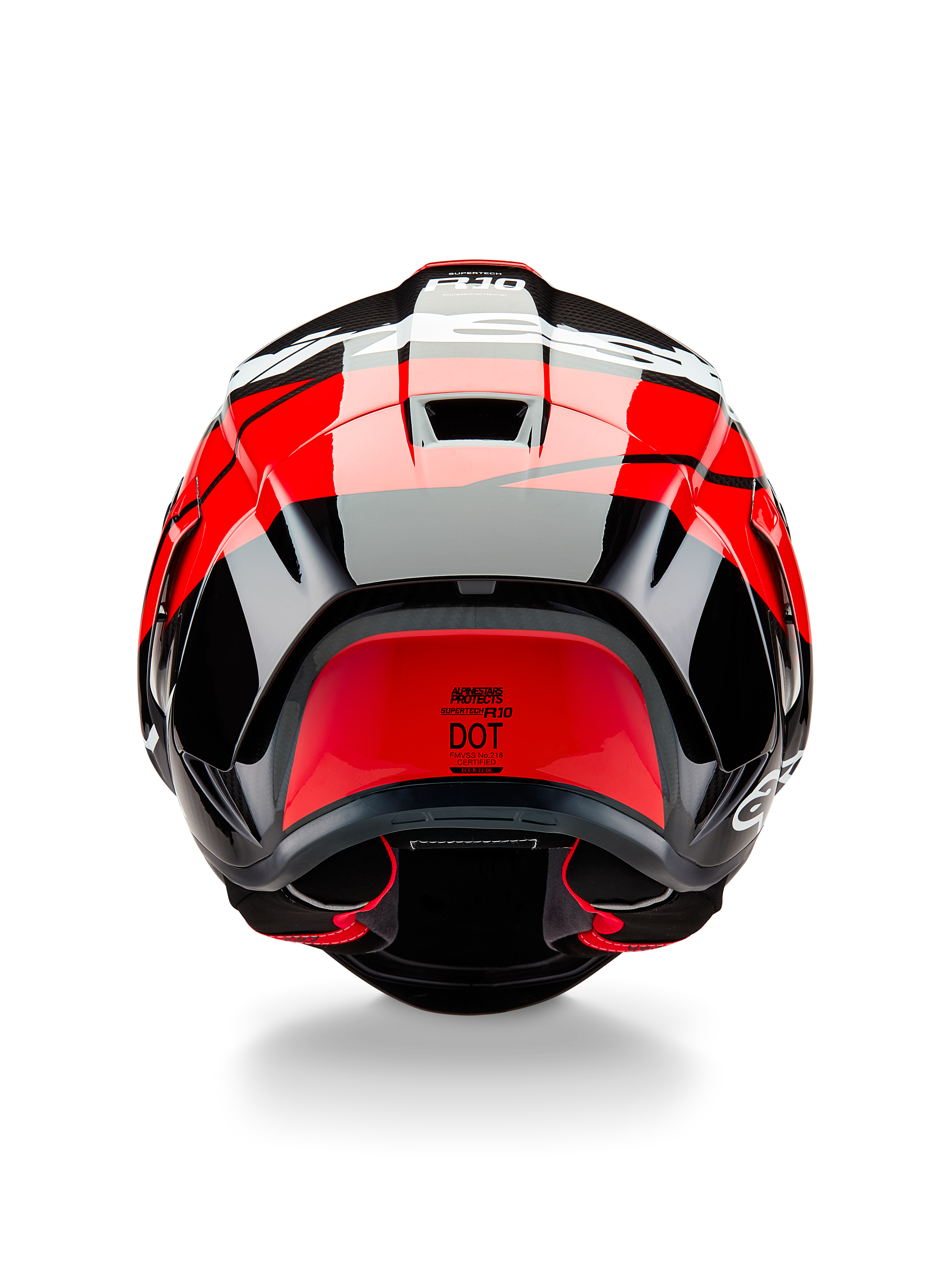Alpinestars Supertech R10 Element-hjelm, set bagfra, sort kulfiber med klare røde og hvide blanke detaljer, med en aerodynamisk bagspoiler, udluftningsventiler og DOT-certificeringsmærkat, strømlinet racerinspireret design med kulfiberdetaljer