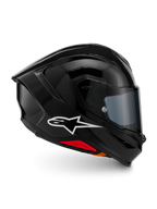 Alpinestars S-R7 Solid hjelm, full-face motorcykelhjelm, blank sort, profilvisning med et hvidt A-star-logo, strømlinet aerodynamisk skal med integreret spoiler og røde detaljer ved bunden, designet til racing og sportspræstationer.