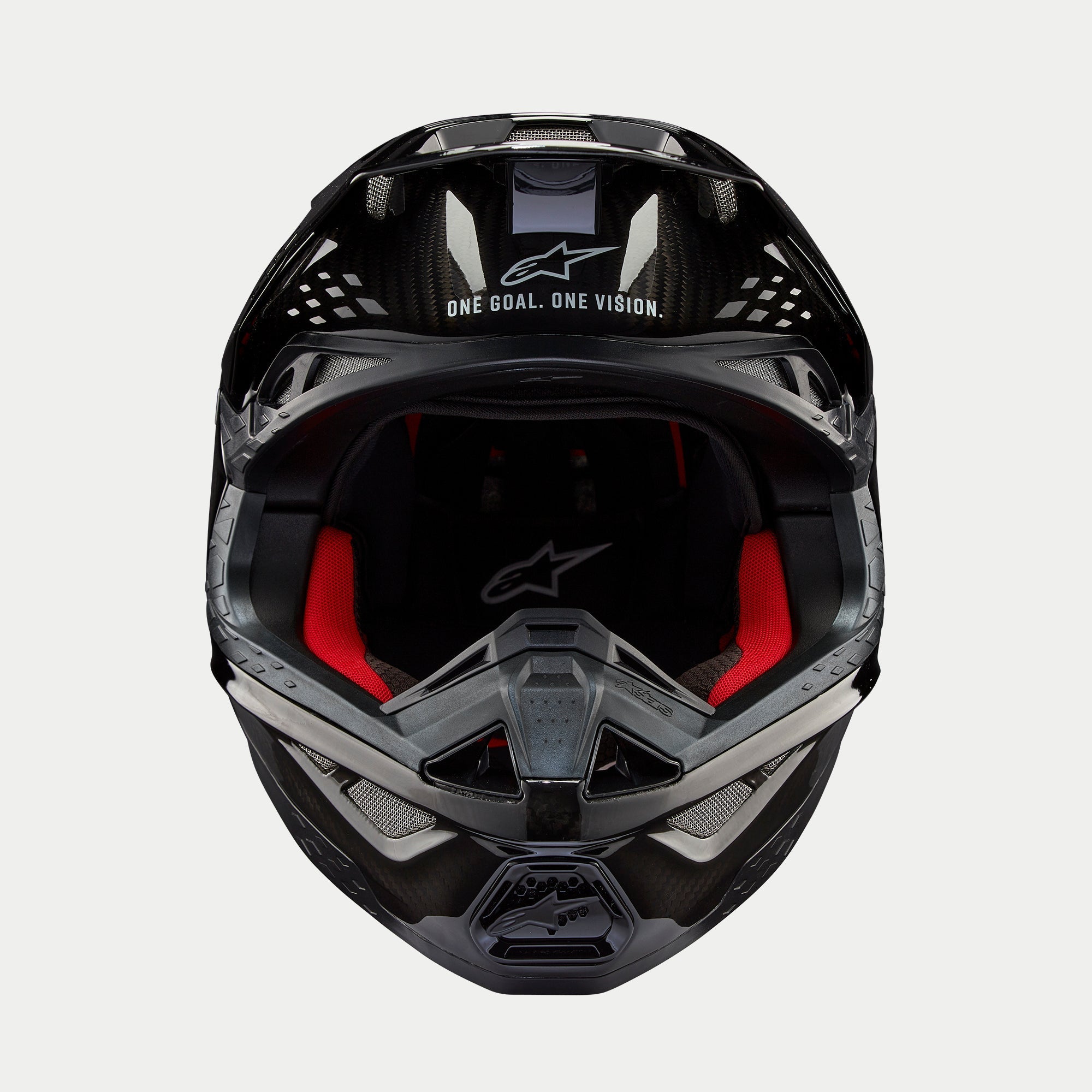 Alpinestars Supertech M10 Solid hjelm, motocrosshjelm, sort blank kulfiber, set forfra med rødt indvendigt for, kulfiberskal og "ONE GOAL. ONE VISION." slogan på visiret