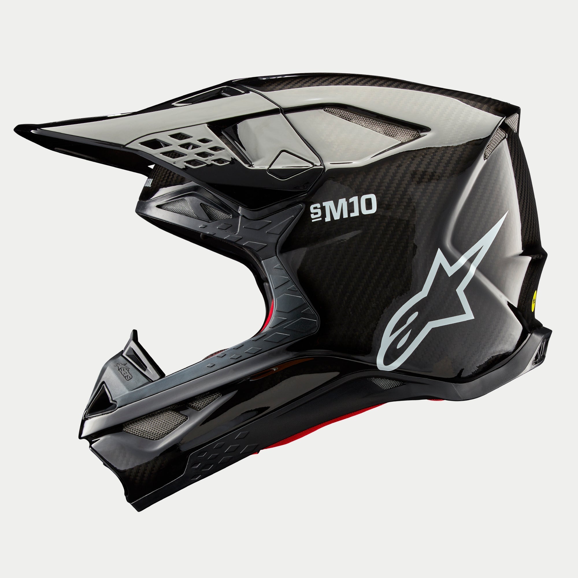 Alpinestars Supertech M10 Solid hjelm, motocrosshjelm, sort blank carbon, sideprofil med synlig kulfibervævning, hvidt SM10-logo og Alpinestars-logo, strømlinet aerodynamisk design med mesh-dækkede ventilationsåbninger