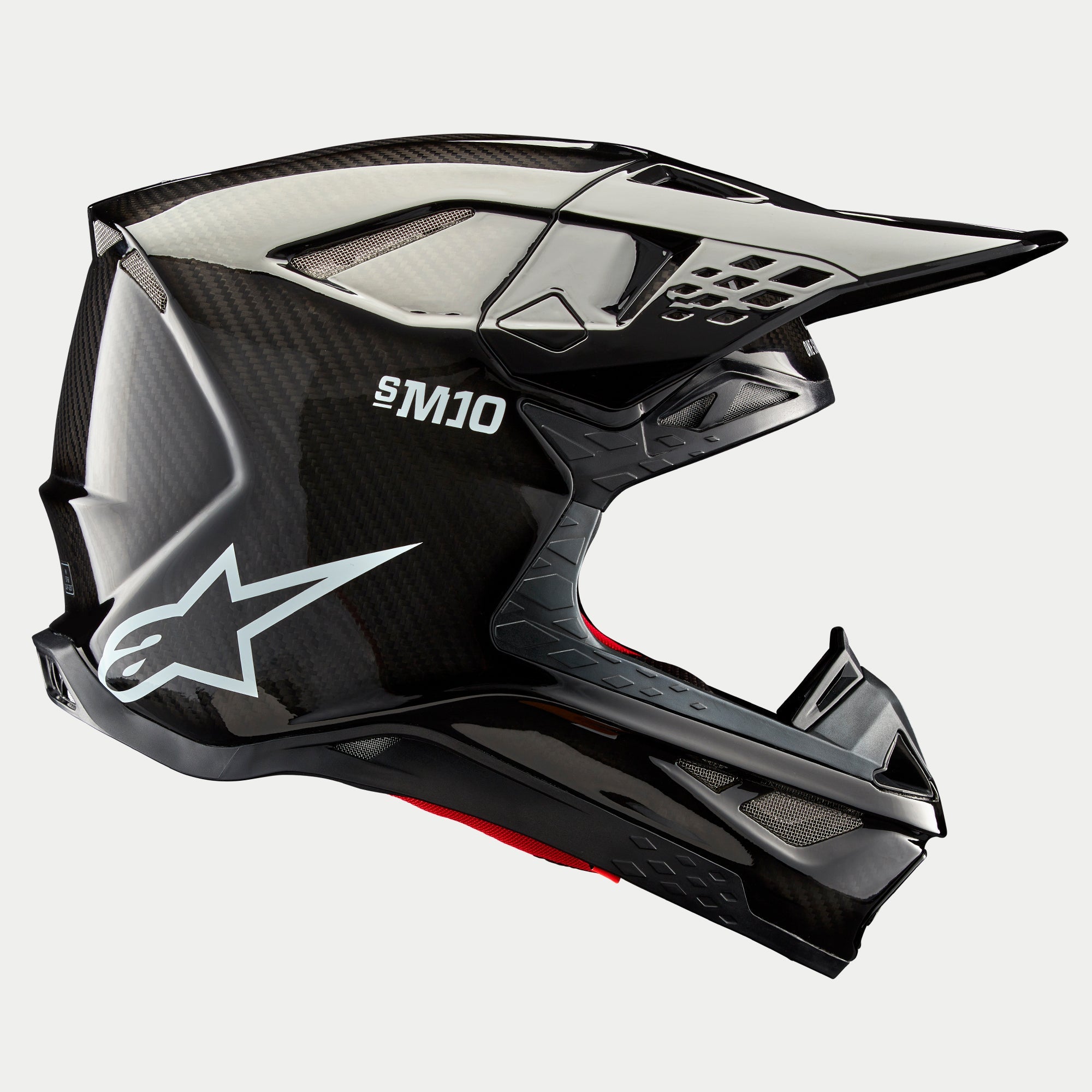 Alpinestars Supertech M10 Solid hjelm, sort blank carbon, motocrosshjelm, sideprofil der viser blank kulfibervævning, S-M10-branding, hvidt Alpinestars-stjernelogo, aerodynamisk design med skygge og ventilationsporte