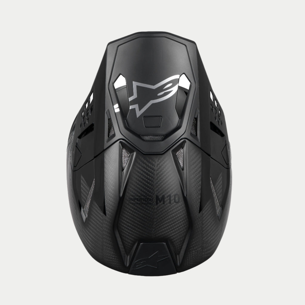Alpinestars Supertech M10 Fame ECE 22.06 hjelm, motocrosshjelm, sort carbon mat og blank, top-down visning der fremhæver kulfibervævningen, aerodynamisk visir med sølvfarvet Alpinestars-logo og flere ventilationsåbninger til off-road racing.