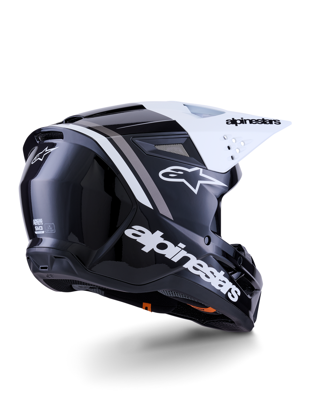 Alpinestars S-M3 Radium hjelm, motocross-hjelm, sort, hvid og grå blank, set skråt bagfra med hvidt visir, markant Alpinestars-logo på siden og bagpå, strømlinet aerodynamisk skal med ventilationsnet, designet til off-road motocross og enduro