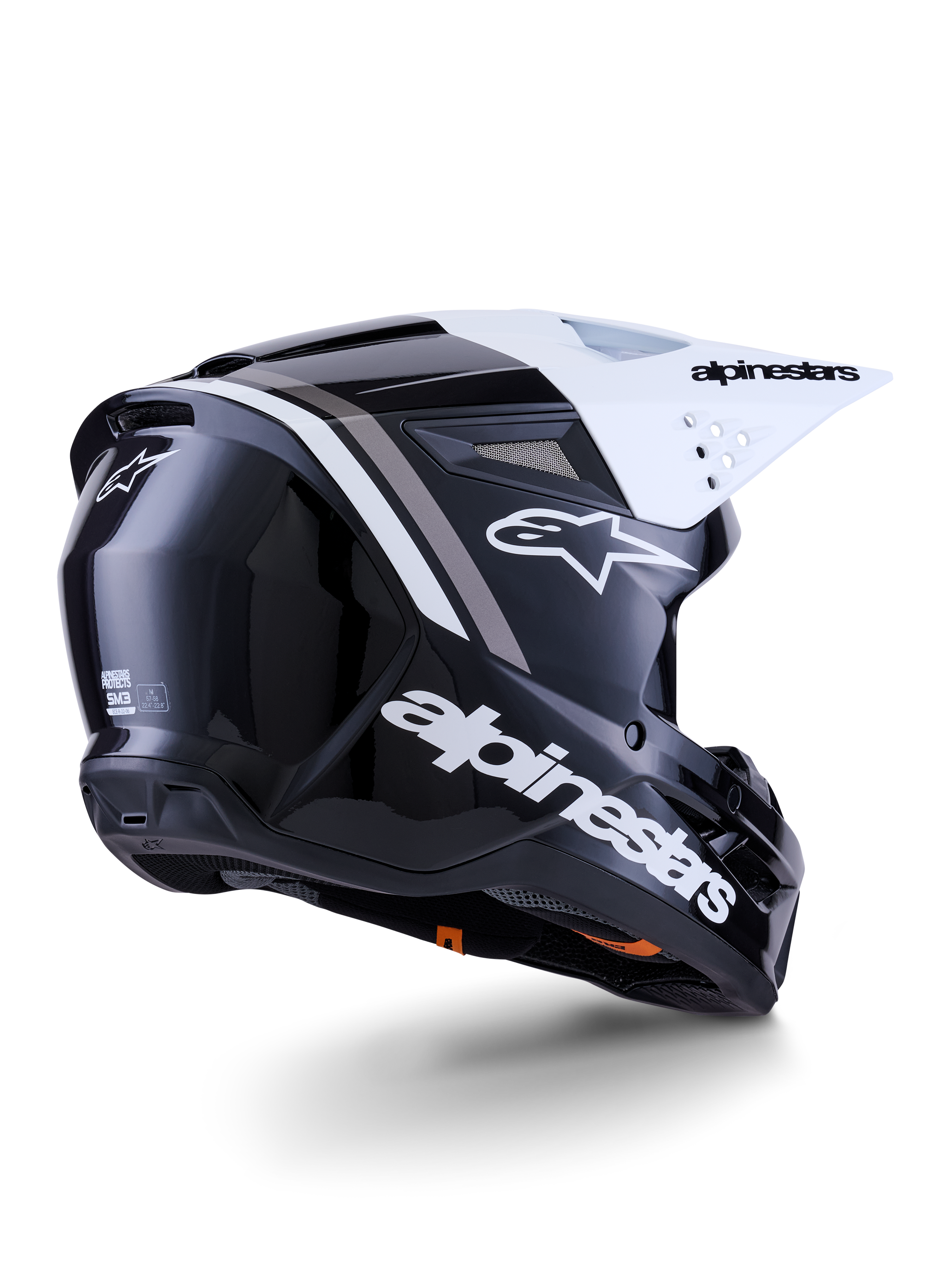 Alpinestars S-M3 Radium hjelm, motocross-hjelm, sort, hvid og grå blank, set skråt bagfra med hvidt visir, markant Alpinestars-logo på siden og bagpå, strømlinet aerodynamisk skal med ventilationsnet, designet til off-road motocross og enduro
