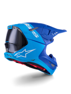 Alpinestars Supertech M10 Flood-hjelm, motocross-hjelm, lyseblå og navyblå med synlig sort kulfiber, profil fra bagside og side, der viser ventilationsporte og hvidt logo, rødt indvendigt for, avanceret aerodynamisk design til terrænkørsel