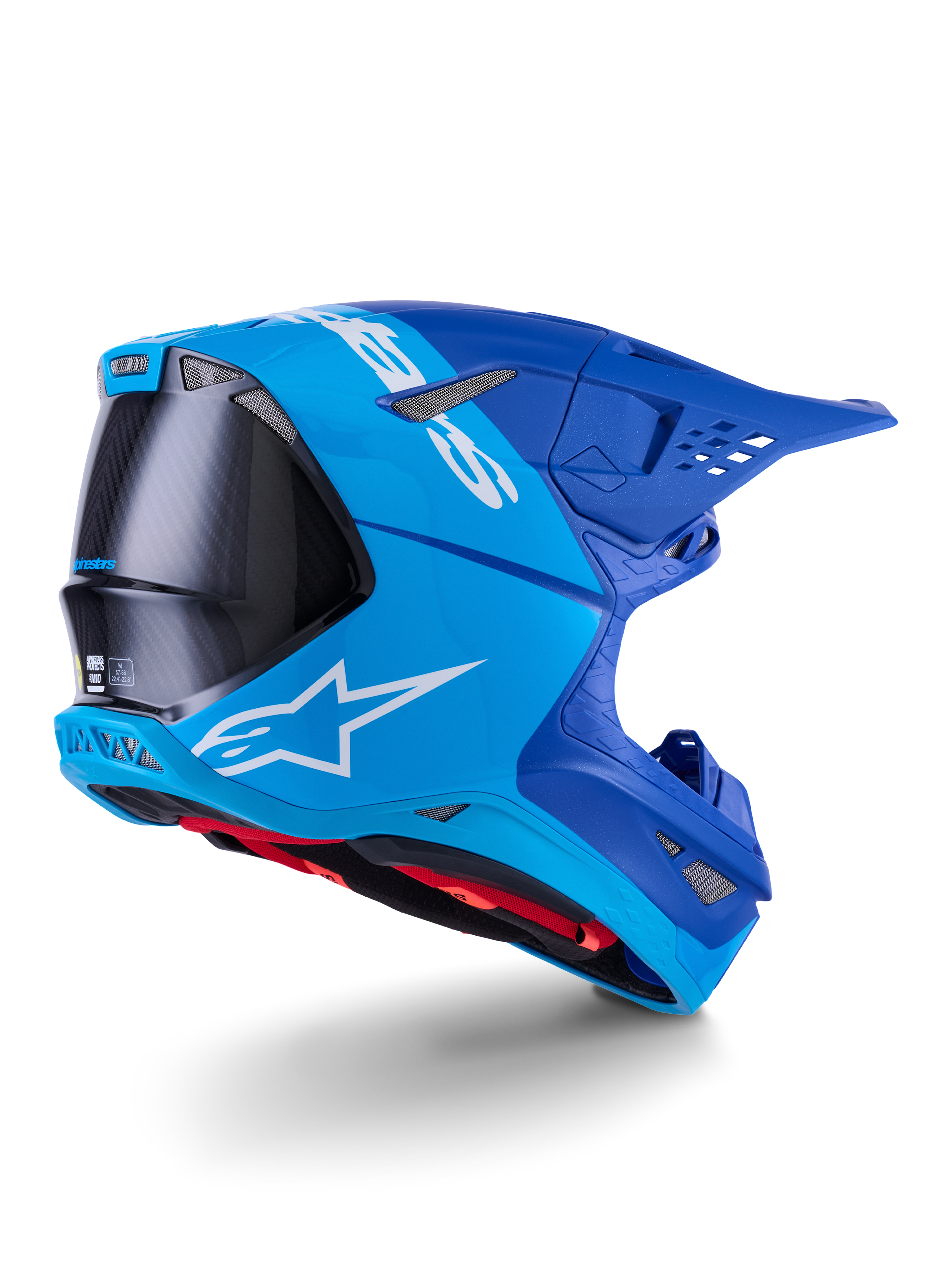 Alpinestars Supertech M10 Flood-hjelm, motocross-hjelm, lyseblå og navyblå med synlig sort kulfiber, profil fra bagside og side, der viser ventilationsporte og hvidt logo, rødt indvendigt for, avanceret aerodynamisk design til terrænkørsel