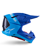 Alpinestars Supertech M10 Flood-hjelm, motocross-hjelm, metallic og mellemblå med sorte carbon-detaljer, sideprofil, hvidt logo, aerodynamisk design med ventilationsporte, kulfibertekstur, professionel off-road racingbeskyttelse