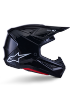 Alpinestars S-M7 Solid hjelm, motocross racinghjelm, blank sort med hvidt stjerne-logo og røde detaljer, sideprofil med aerodynamisk design, kantede ventilationsåbninger og Supertech M7-branding på visiret.