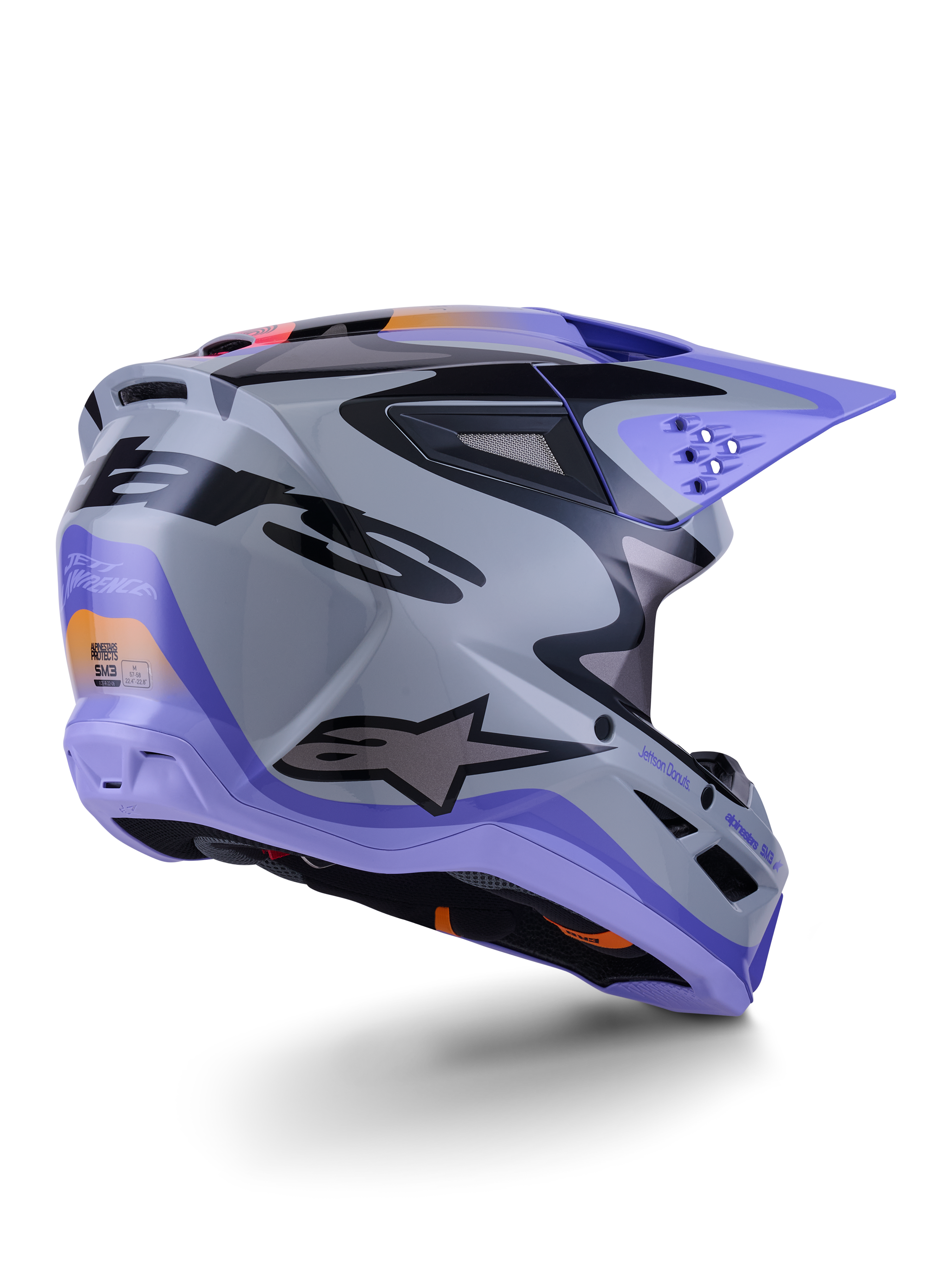 Alpinestars S-M3 Jettson hjelm ECE 22.06, motocross-hjelm, grå, lilla og sort blank, set bagfra i trekvart profil, der viser den aerodynamiske termo-injicerede skal med ventilationsåbninger og markant grafisk design
