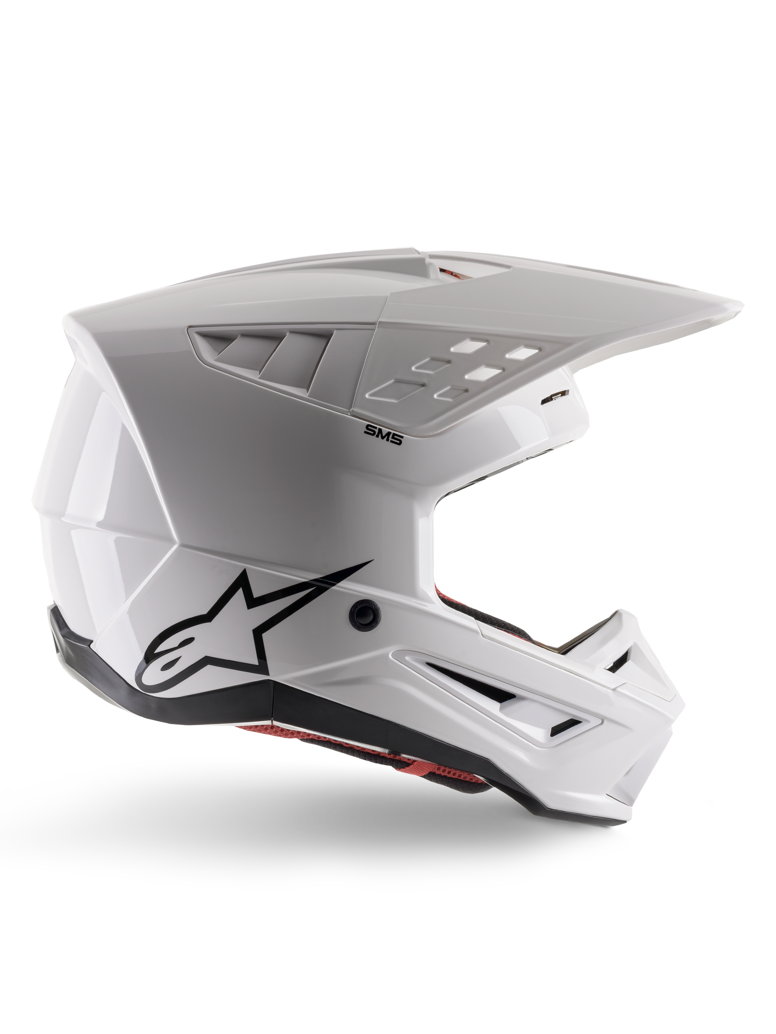 Alpinestars S-M5 Solid-hjelm ECE 22.06, motocross-hjelm, blank hvid, sideprofil med et kantet aerodynamisk design, fremtrædende skygge, integrerede luftventiler, sort Astars-logo bagpå og synlig rød indvendig polstring