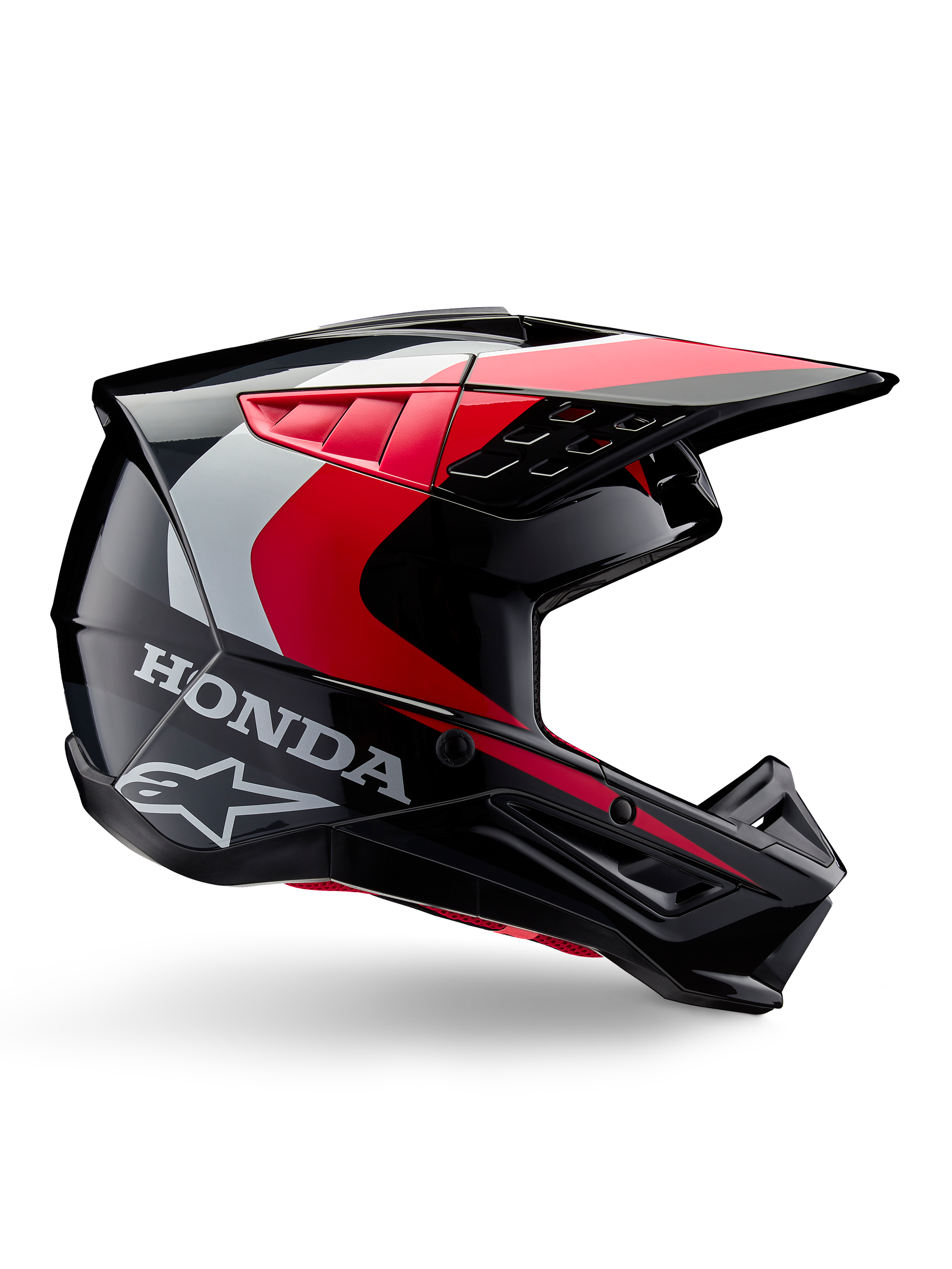 Honda S-M5 hjelm, motocross-hjelm, blank sort og rød med hvide og sølvfarvede detaljer, set fra siden med Honda- og Alpinestars-logoer, aerodynamisk design med visir og flere ventilationsåbninger, professionelt beskyttelsesudstyr til off-road