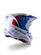 Alpinestars Honda S-M5 ECE hjelm, motocrosshjelm, hvid, blå og rød blank, med markant Honda-branding og Alpinestars-logoer, aerodynamisk skal med integrerede ventilationsåbninger og justerbart visir, beskyttelsesudstyr til terrænkørsel