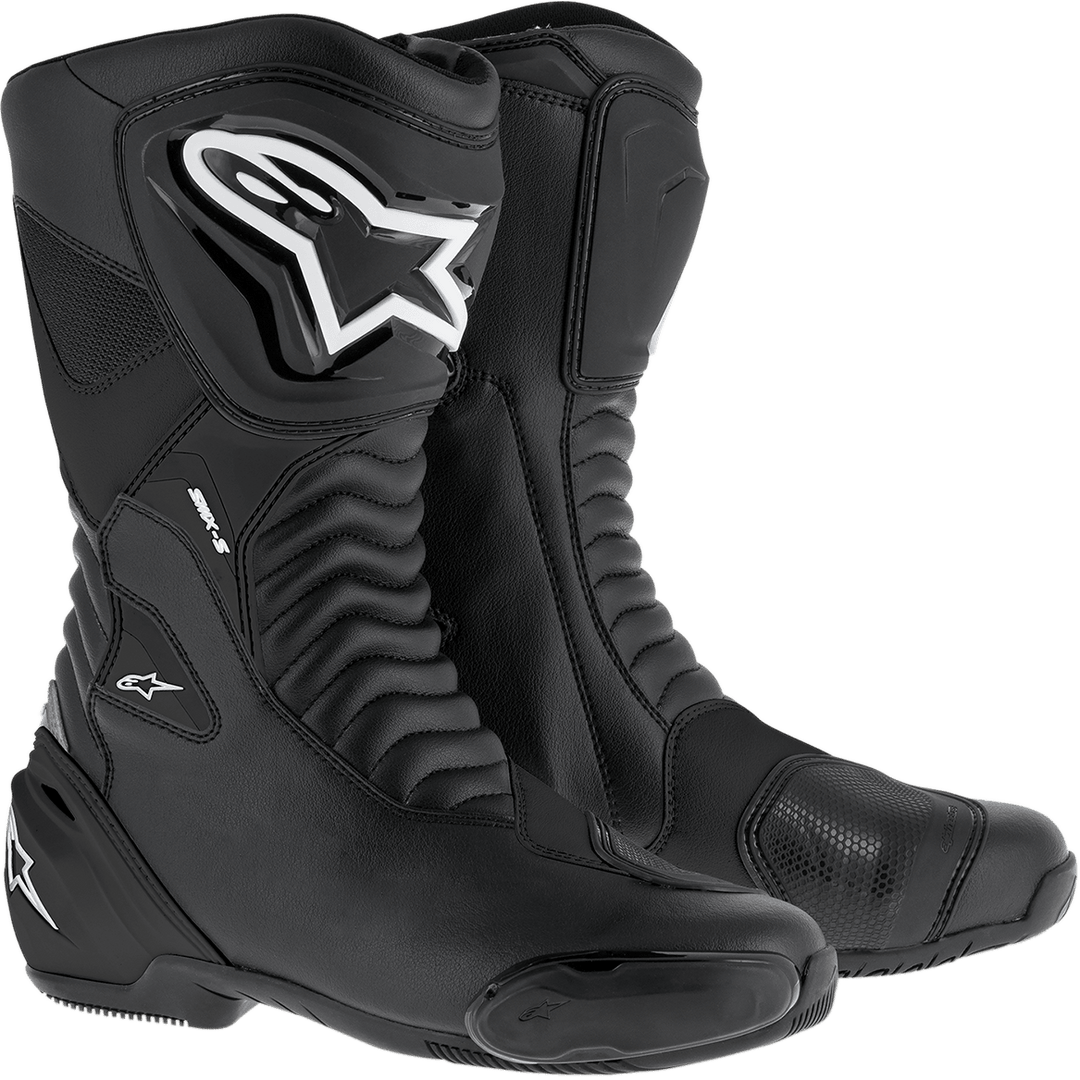 A pair of SMX S Boots by Alpinestars EU in black/black featuring reinforced ankle and shin protection, a white star logo, and ribbed detailing for flexibility. These boots boast a durable microfiber upper, high collars, and Alpinestars’ exclusive rubber compound sole, providing both style and advanced protective features for riders.