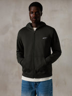 Alpinestars Essentials Ageless Zip Hoodie, Off Black, hættetrøje med gennemgående lynlås og et lille hvidt Alpinestars-logo på brystet, afslappet pasform, båret af en model med blå jeans og hvid t-shirt, afslappet motorsport-inspireret streetwear