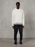 Alpinestars Essentials Ageless Zip Hoodie, afslappet streetwear, off-white med diskret sort logo på brystet, gennemgående lynlås, design med hætte, afslappet pasform, stylet med sorte joggingbukser og sneakers