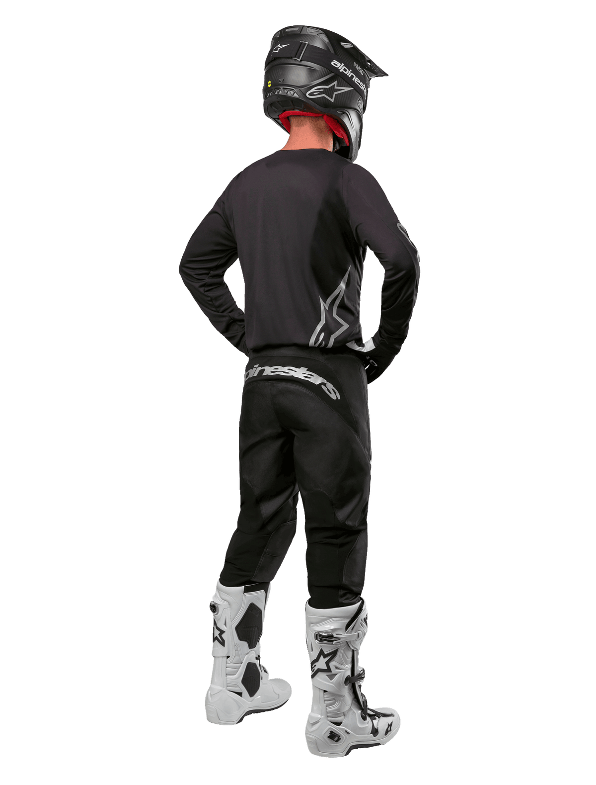 Alpinestars 2024 Fluid Graphite-gearsæt, motocross-kører set bagfra, grafitgrå jersey og bukser med sølvfarvet Alpinestars-branding, sort hjelm og hvide motocross-støvler, udstyr med atletisk pasform til off-road-kørsel