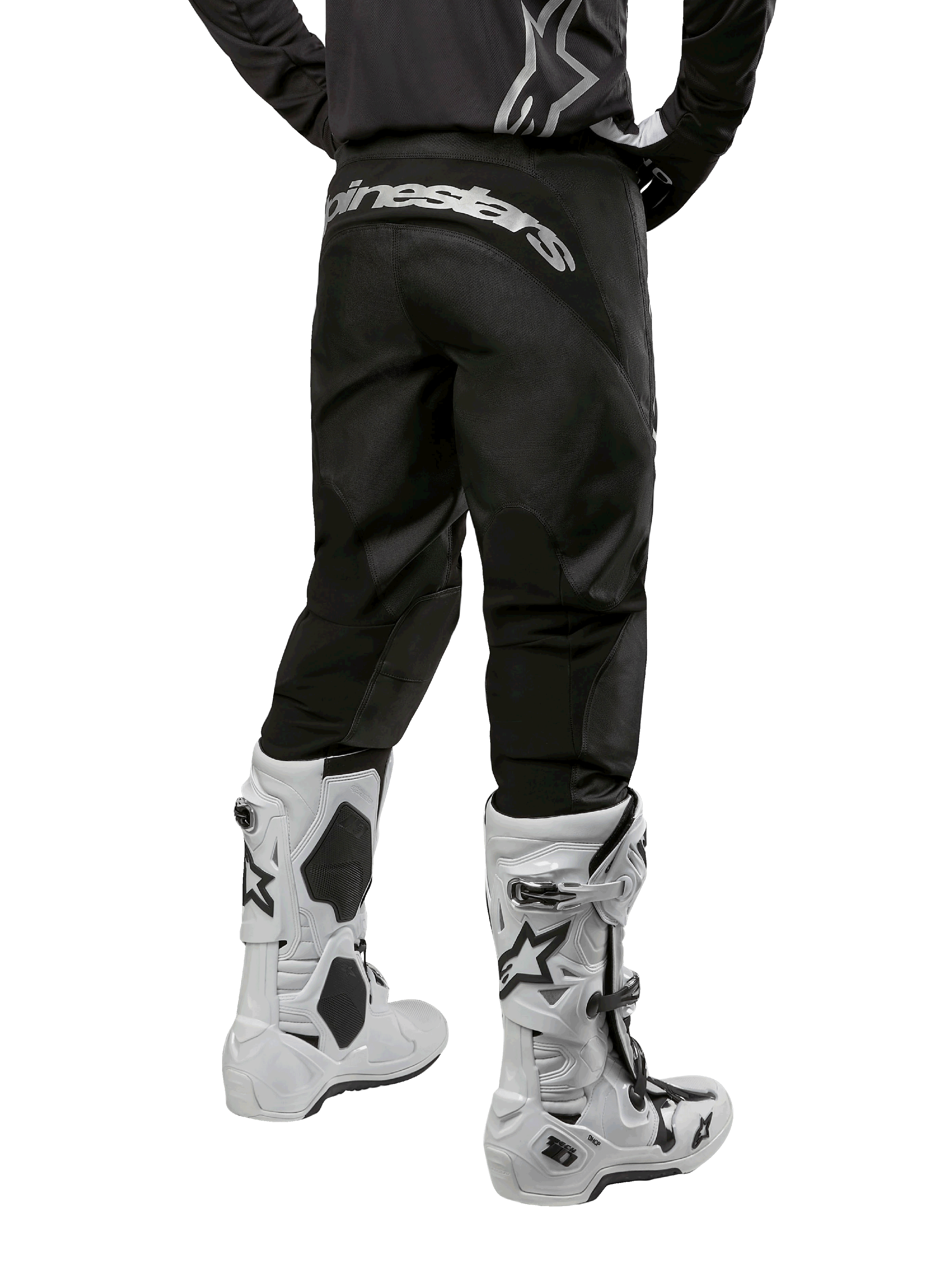 Alpinestars 2024 Fluid Graphite-udstyrssæt, set bagfra af sorte og grå motocrossbukser med hvidt Alpinestars-branding på bagdelen, båret med hvide og sorte motocross-støvler, specialiseret off-road-racerudstyr