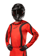 2024 Fluid Lurv Jersey, motocross racertrøje, Hot Orange og sort, langærmet med buede sorte striber, Alpinestars-logoer på bryst og skuldre, båret med sort hjelm og handsker, atletisk off-road udstyr