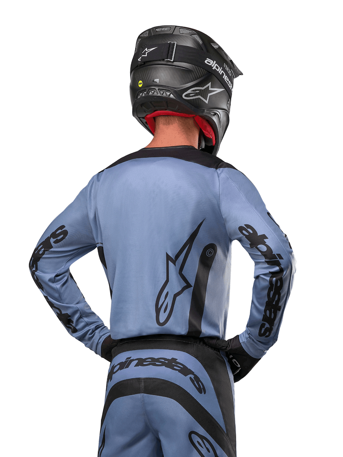Alpinestars 2024 Fluid Lurv trøje, motocross-trøje, lyseblå og sort, rygbillede af kører, der viser stort stjernelogo og branding på ærmerne, båret med en sort hjelm og matchende off-road bukser, professionelt racertøj