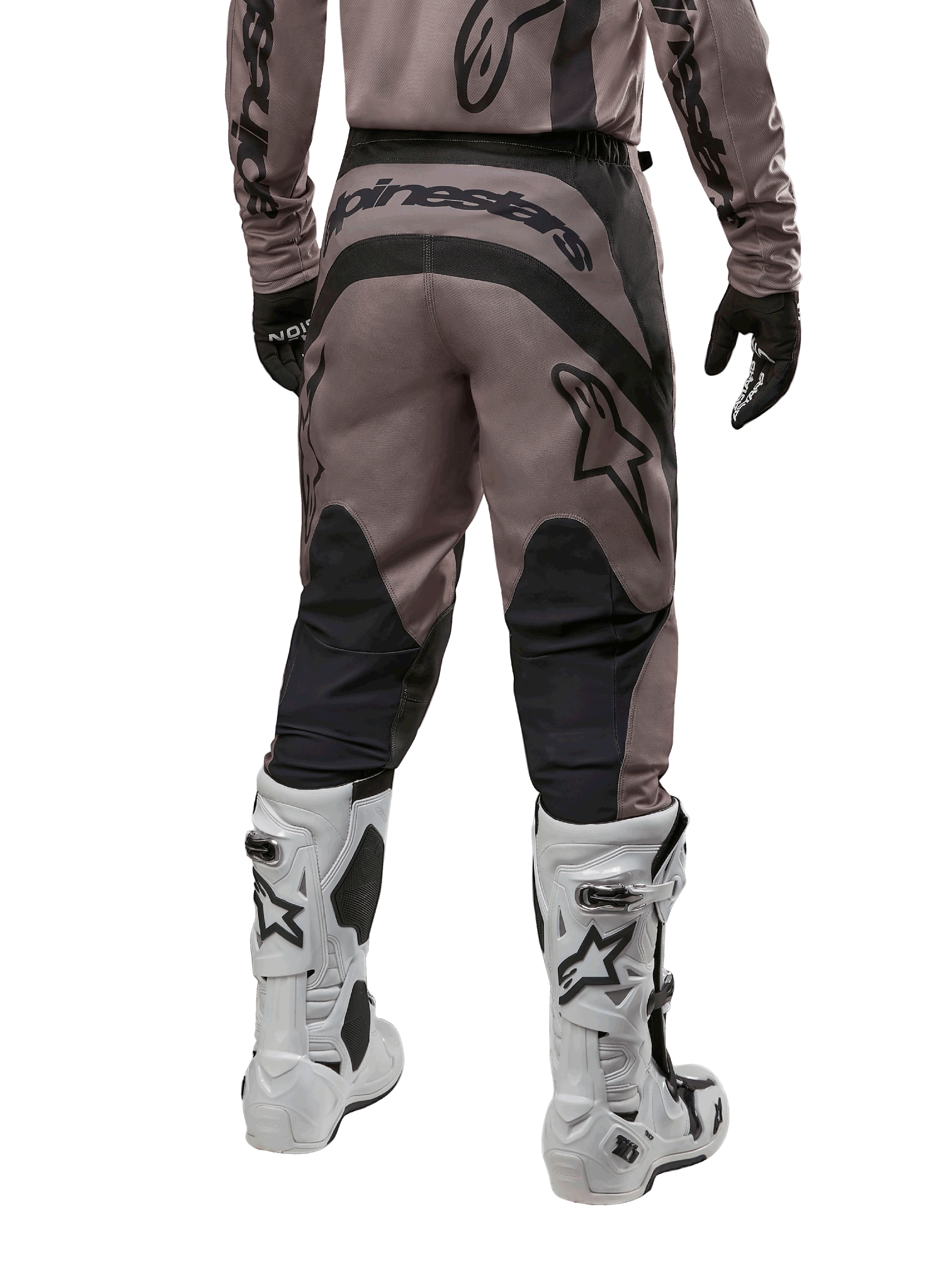 Alpinestars 2024 Fluid Lurv-bukser, motocross-bukser, Mud Black, set bagfra med stort sort Alpinestars-logo på bagen og sorte lægpaneler, båret med hvide og sorte motocross-støvler og matchende trøje.