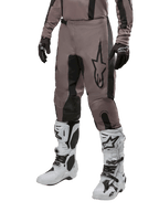 Alpinestars 2024 Fluid Lurv bukser, motocross-bukser, Mud Black og sort, med Alpinestars-logo, vist med sorte handsker og hvide motocross-støvler, sporty design til terrænkørsel
