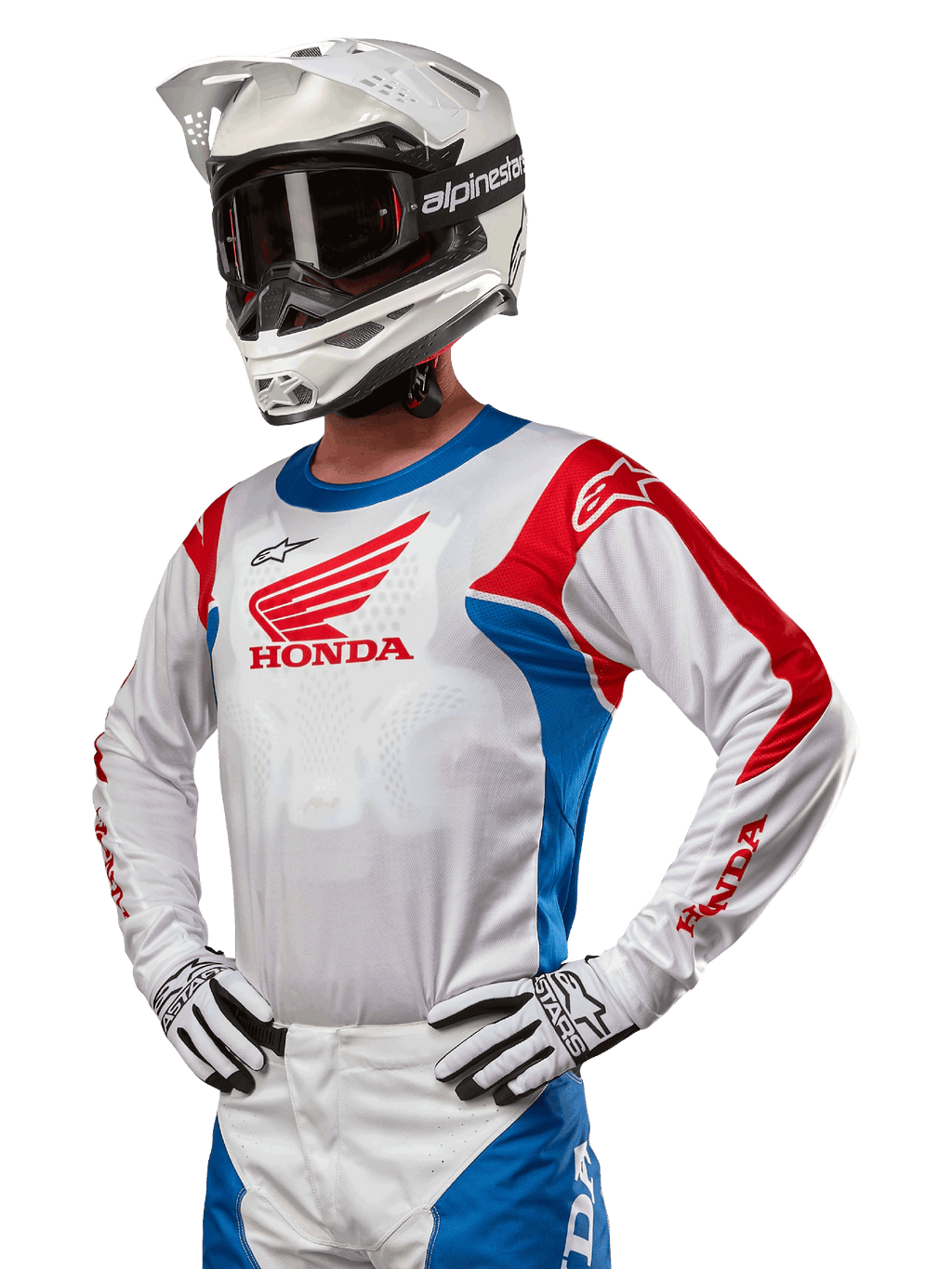 Motocrosskører iført Honda Racer Iconic Jersey i hvid, klar blå og klar rød, med et stort Honda-vingelogo på brystet, kombineret med hvid Alpinestars-hjelm og matchende hvide og sorte handsker, koordineret udstyr til terrænkørsel