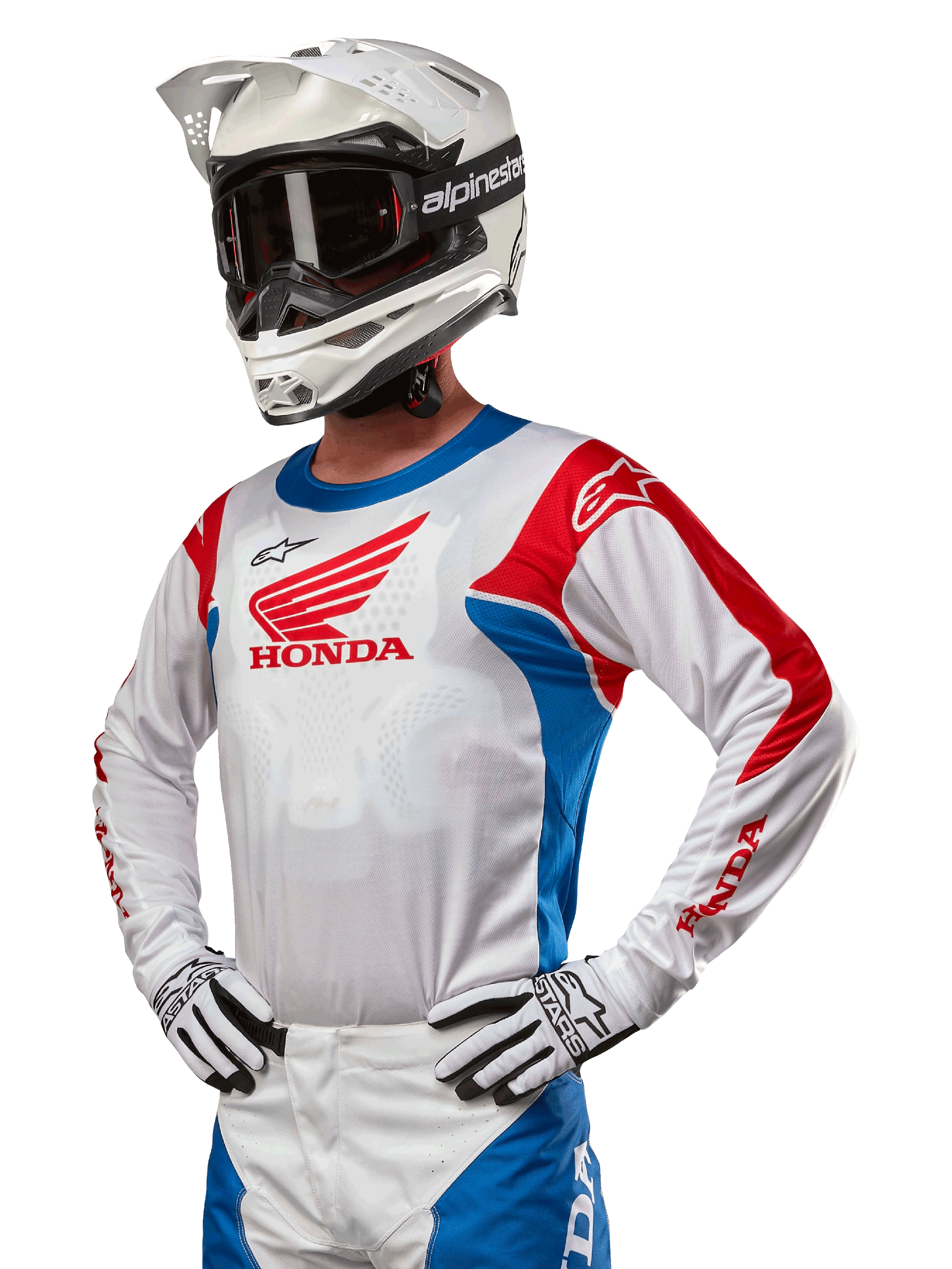 Motocrosskører iført Honda Racer Iconic Jersey i hvid, klar blå og klar rød, med et stort Honda-vingelogo på brystet, kombineret med hvid Alpinestars-hjelm og matchende hvide og sorte handsker, koordineret udstyr til terrænkørsel