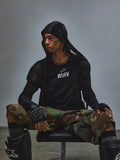 Alpinestars RSRV Nucleon kortærmet t-shirt, sort med hvidt RSRV-logo, unisex streetwear, vist med camouflage bukser og beskyttelsesudstyr, urban motorsport stil