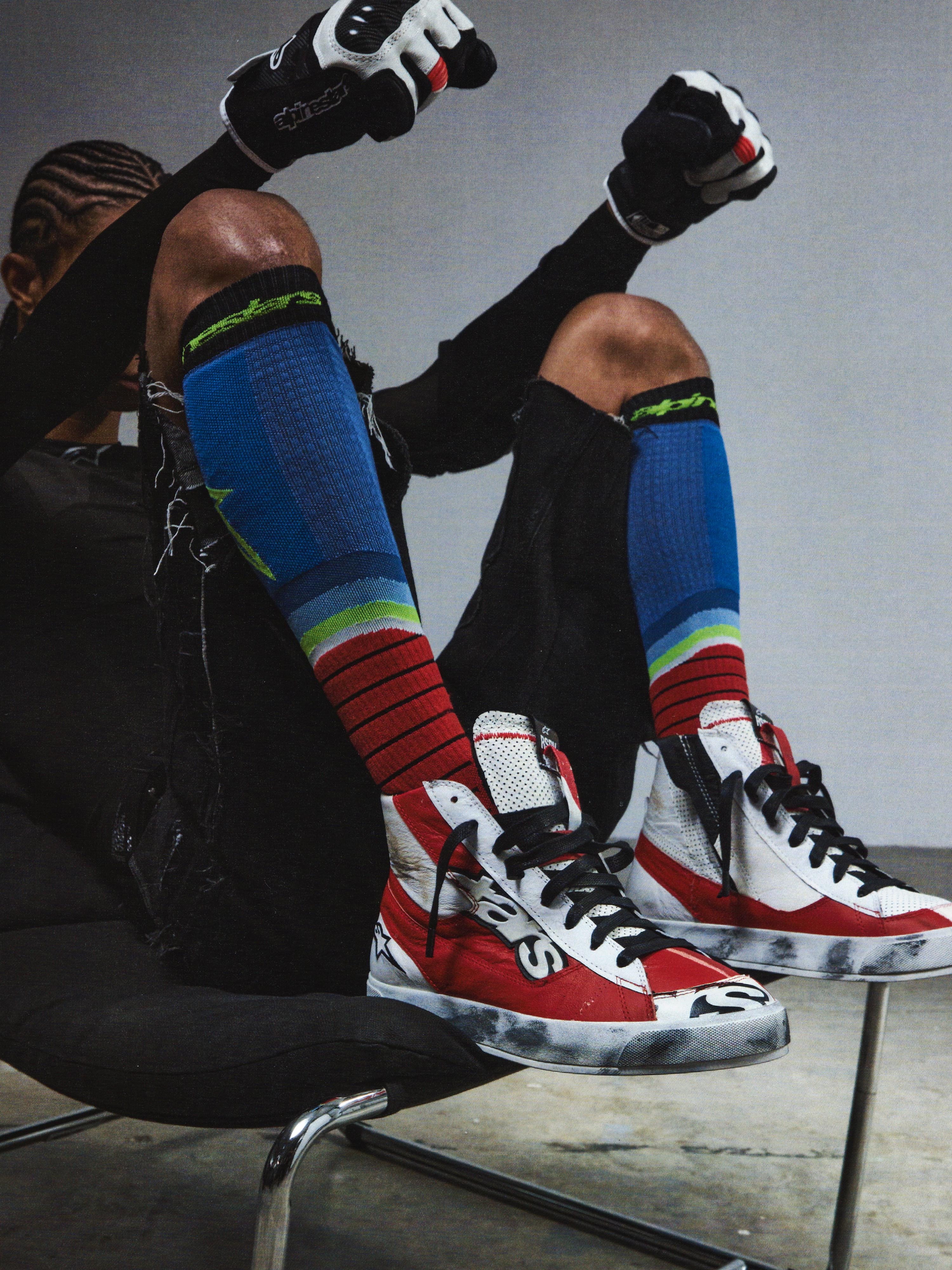 Alpinestars RSRV Legacy Shoe, lifestyle-sneakers, rød, hvid og sort, person iført farverige stribede strømper og sorte handsker, premium streetwear-kollektion