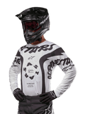 Alpinestars 2024 Racer Hana trøje, motocross racing jersey, hvid og sort, markant grafik med Alpinestars og Astars branding, vist med sort hjelm og sorte handsker, teknisk off-road MX-udstyr
