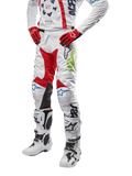2024 Racer Hana bukser, motocross racingbukser, hvid med røde, blå og limegrønne detaljer, beskyttende design med knæpaneler i læder, båret med matchende trøje, røde handsker og hvide støvler med spænder, sporty motorsportsoutfit