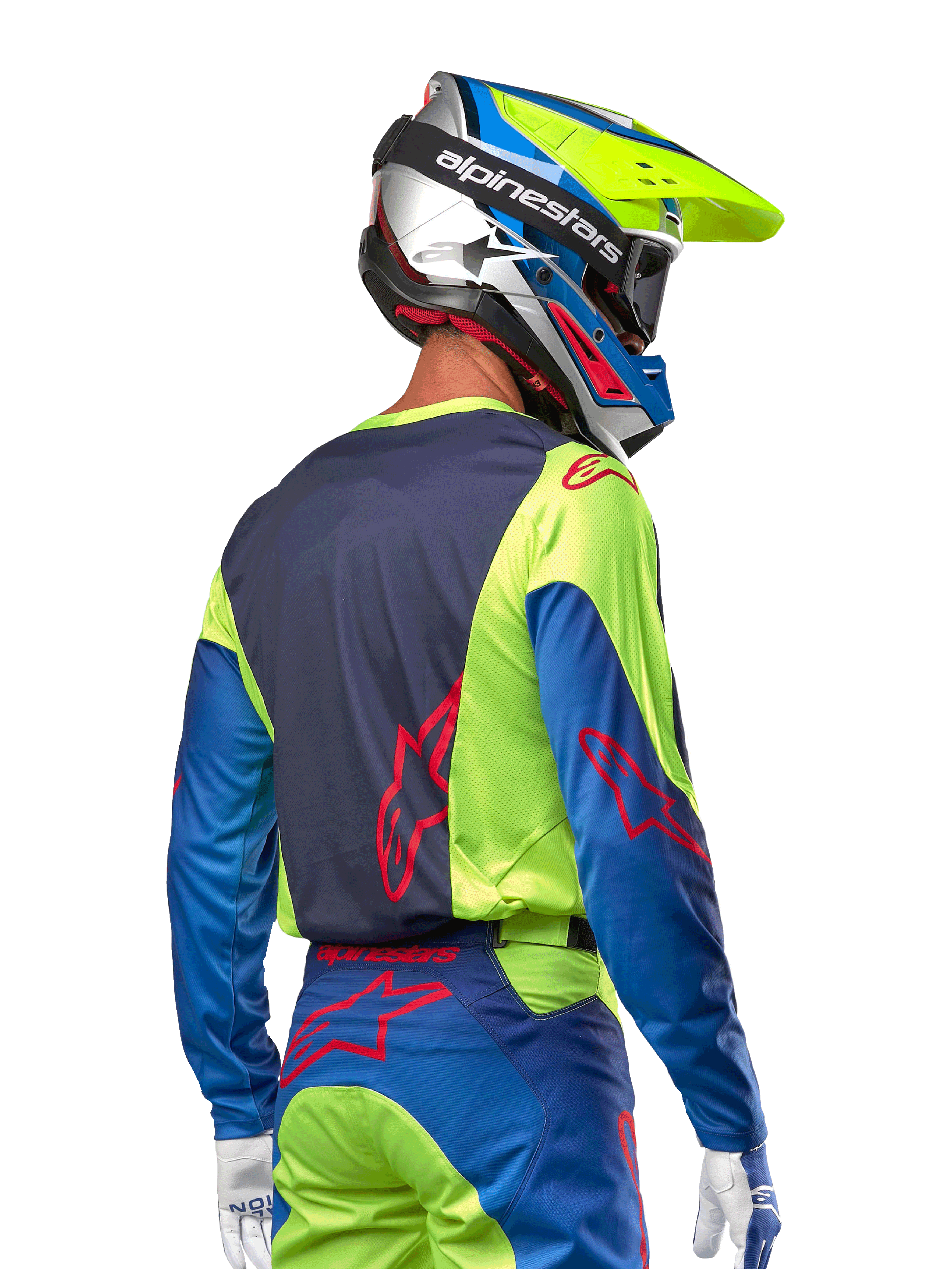 Alpinestars motocrosskører iført 2024 Racer Hoen trøje i Yellow Fluo og Blue Night Navy, med et rødt stjernelogo på ryggen, matchende motocrossbukser og en koordineret racinghjelm, set bagfra, der fremviser det ergonomiske design til off-road kørsel