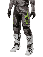 Alpinestars 2024 Racer Tactical bukser, motocross bukser, grå og sort camouflage, limegrønt stjerne-logo, vist med hvide og sorte støvler og sorte handsker, udstyr til terrænkørsel
